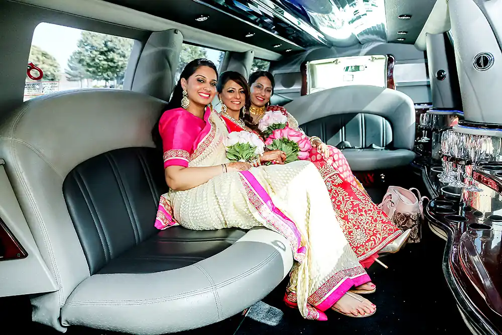 Bride with braidsmaids inside large limousine