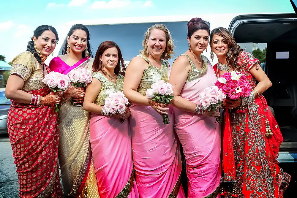 female bridal party in front of an executive limo